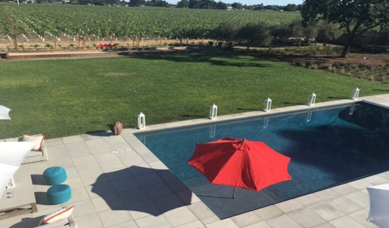 The view of the pool, lawn, bocce ball court and vineyards