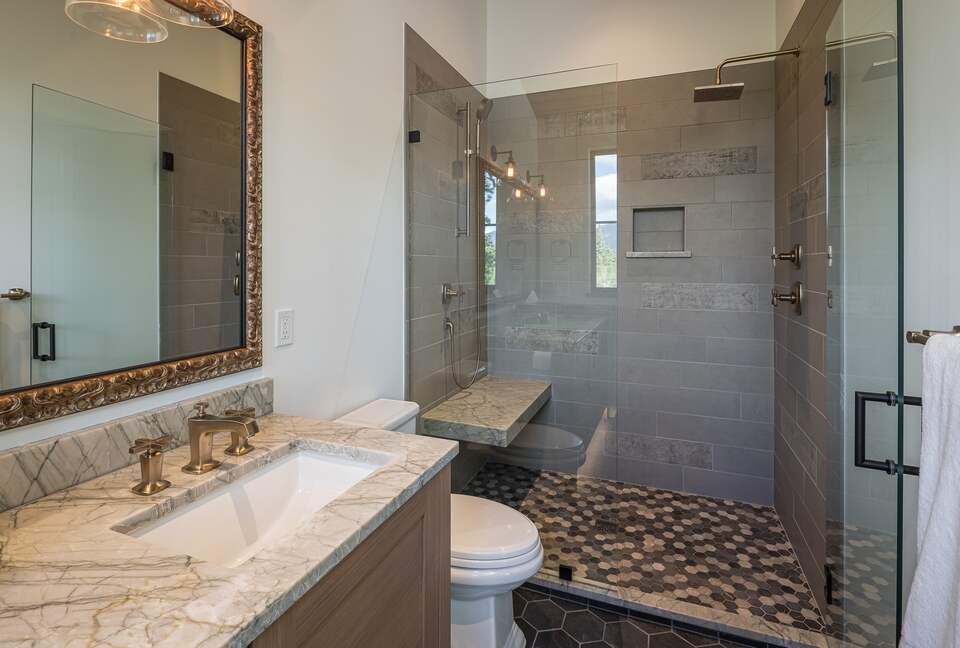 Master bathroom with two sinks, toilet, and walk-in shower.