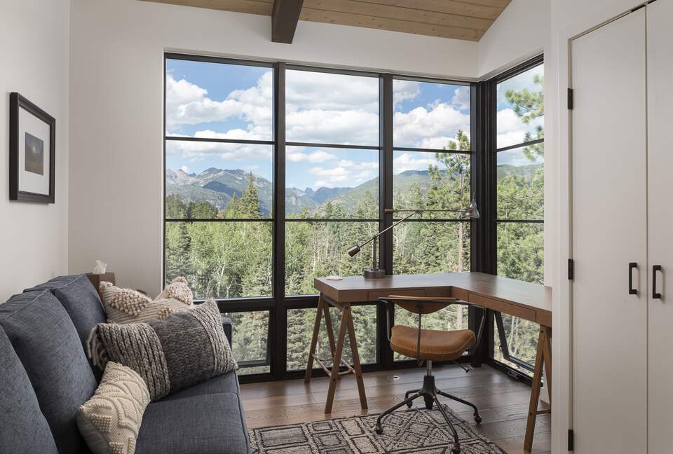 Private reading room with desk, sofa, and mountain views.