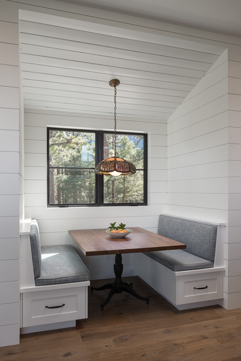 Booth seating with wood table built into shiplap walls