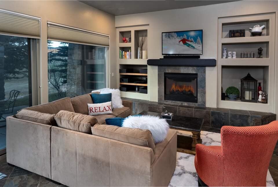 Living room with fireplace, tan sectional, and red arm chair