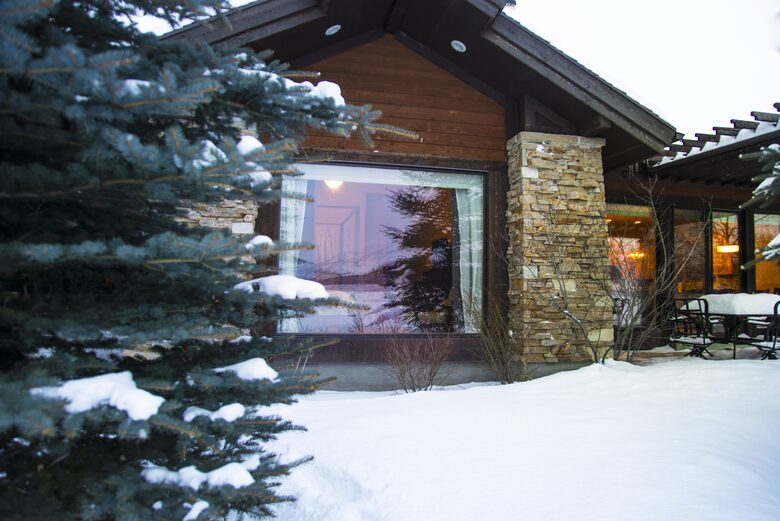 Exterior view of house and pine tree covered in snow