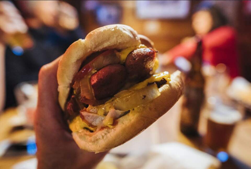 Hand holding a deluxe burger