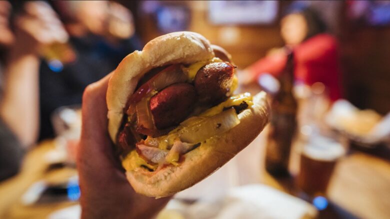 Hand holding a deluxe burger