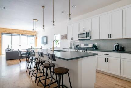 Kitchen with island seats and living area in the background