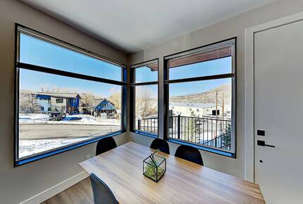 Main floor dining room table next to oversized windows