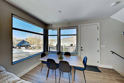 Main floor dining room table next to oversized windows
