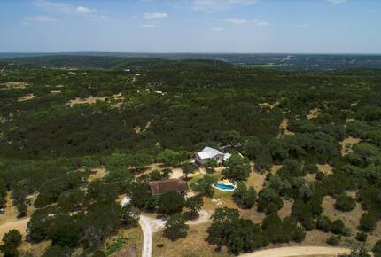 Aerial view of property, pool, and tree landscape