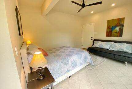 Downstairs master queen bed and dark grey futon couch