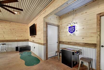 Retreat game room with wood walls & small putting green