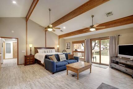Downstairs master bedroom with king bed, blue sofa, and TV