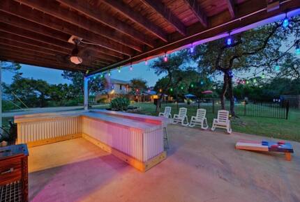 Outdoor bar at night at the Retreat with corn hole game