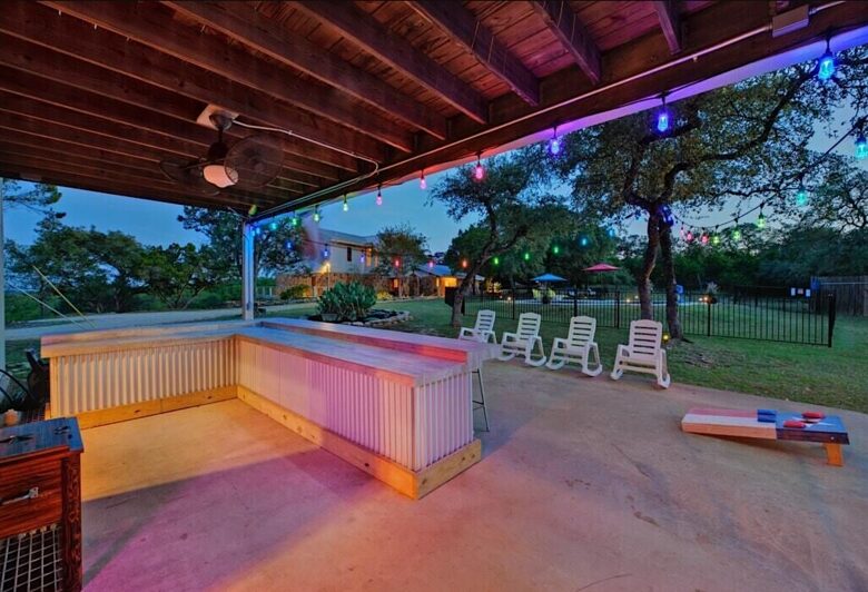 Outdoor bar at night at the Retreat with corn hole game