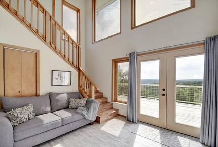 Full grey sleeper sofa, stairs, and french doors