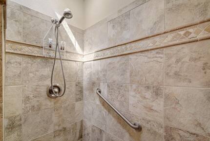 Downstairs master tiled shower with hand rail & shower head