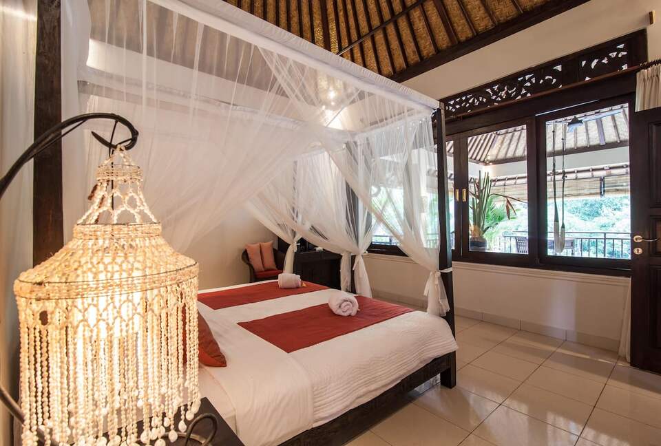 Home exchange in Ubud, Bali, second bedroom canopy bed facing window