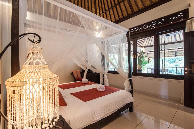 Home exchange in Ubud, Bali, second bedroom canopy bed facing window