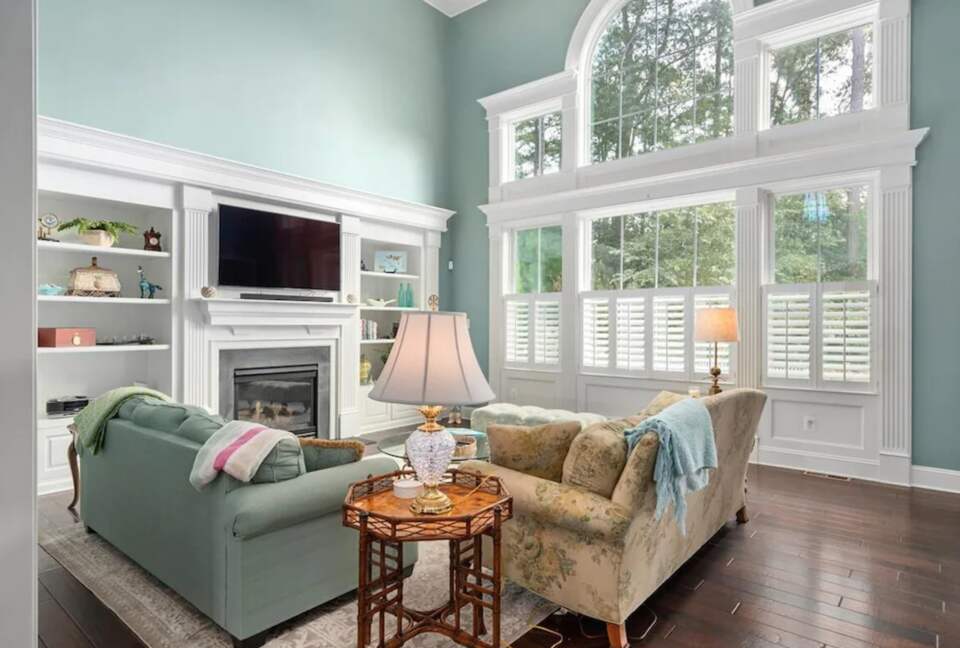 Spacious sun-filled living room with TV