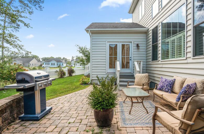 Backyard patio with sitting area and grill