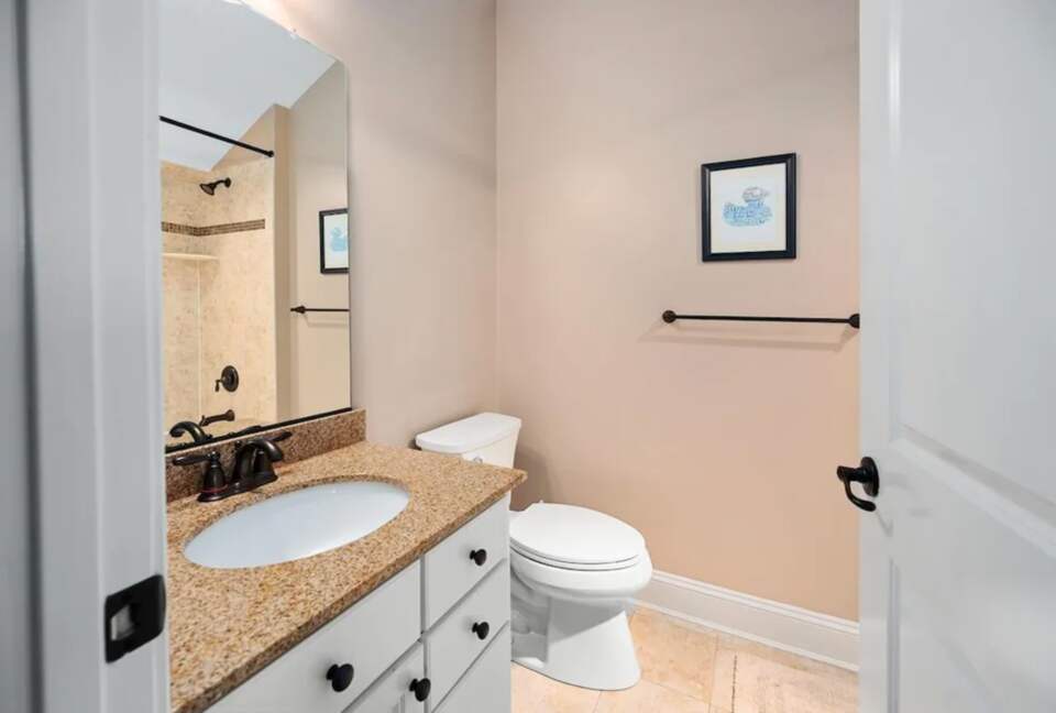 Secondary bathroom with tile floors and granite countertop