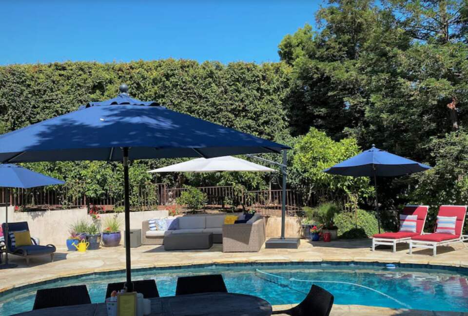 Backyard pool with plenty of seating and umbrellas