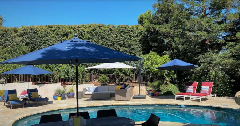 Backyard pool with plenty of seating and umbrellas