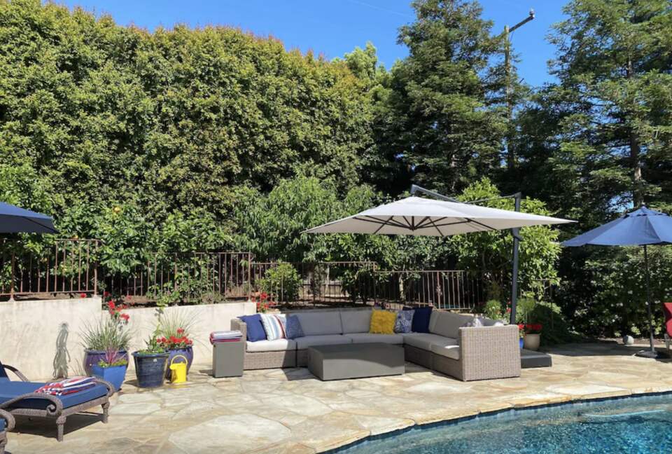Backyard pool with plenty of seating and umbrellas