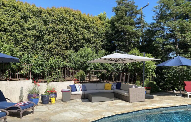 Backyard pool with plenty of seating and umbrellas