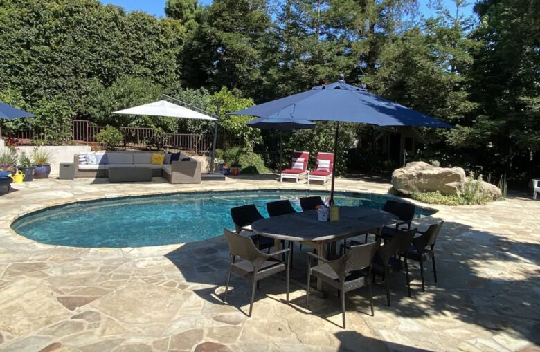Backyard pool with plenty of seating and umbrellas