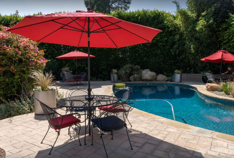 Heated pool with multiple lounge areas and umbrellas