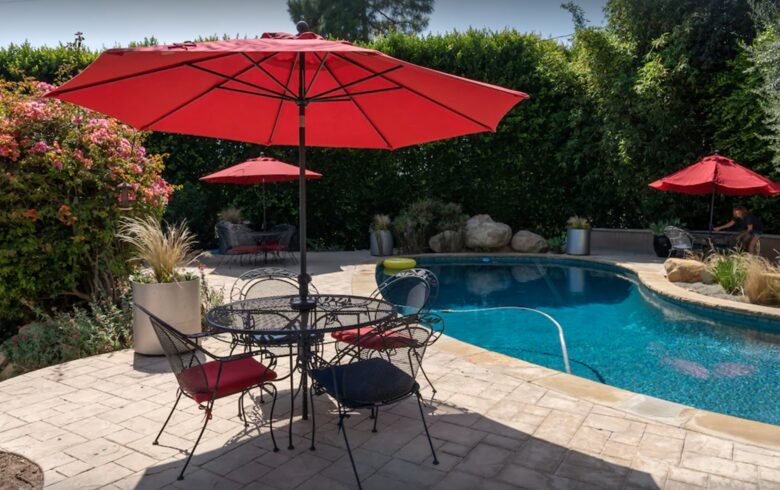 Heated pool with multiple lounge areas and umbrellas
