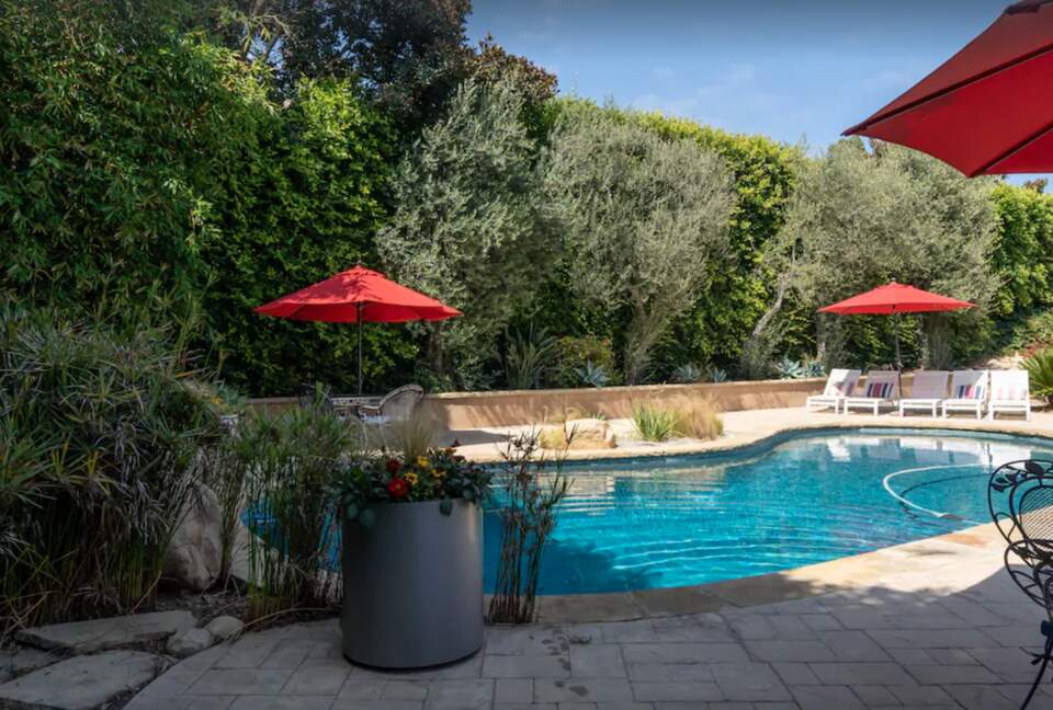 Heated pool with multiple lounge areas and umbrellas