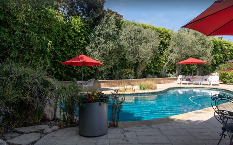 Heated pool with multiple lounge areas and umbrellas