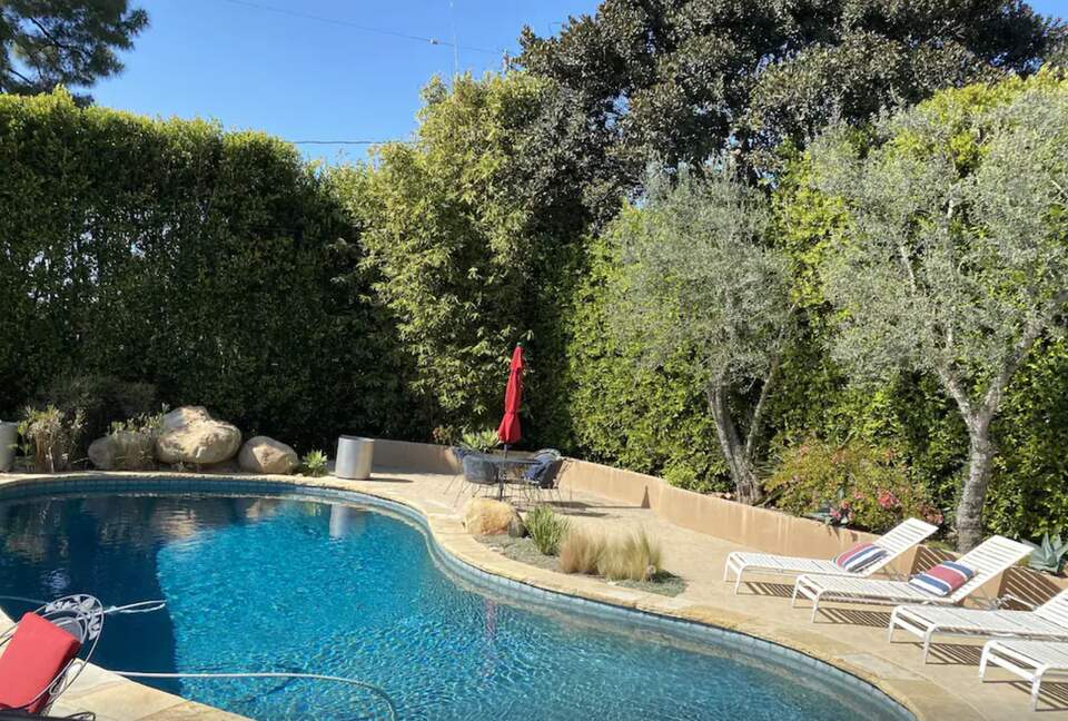 Heated pool with multiple lounge areas and umbrellas