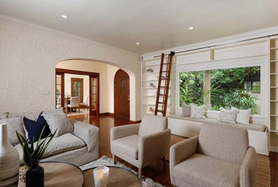 Living room with hardwood floors and library ladder