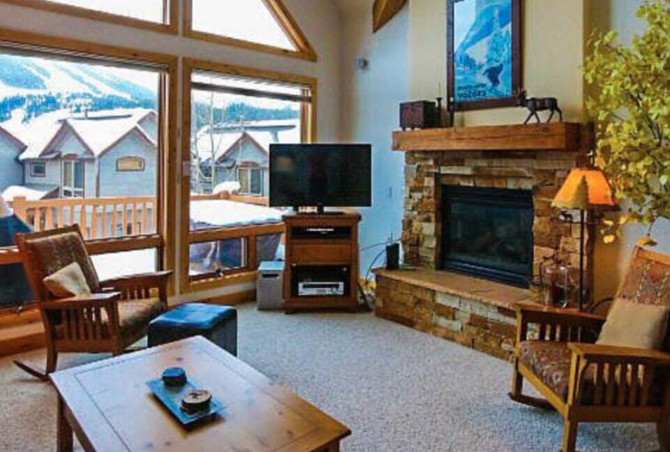 Open living room with fireplace and mountain views