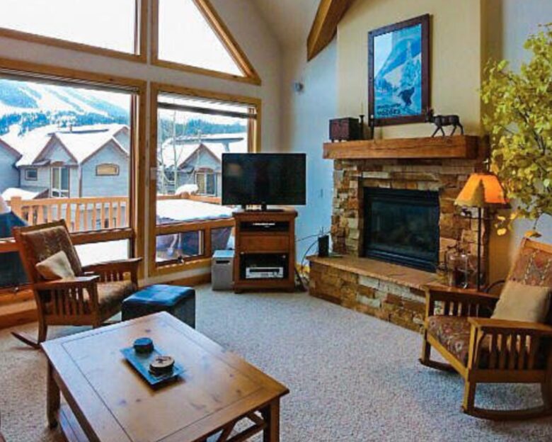 Open living room with fireplace and mountain views