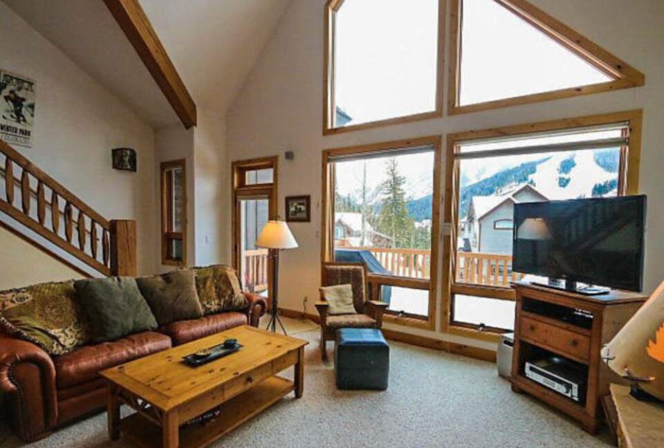 Open living room with fireplace and mountain views