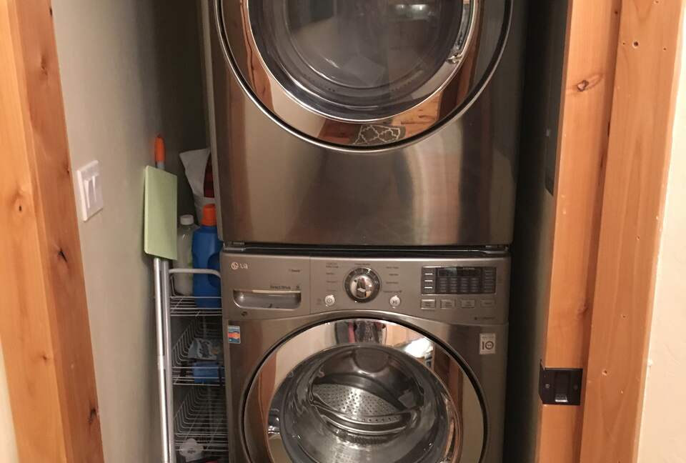 Stacked washer/dryer near kitchen.