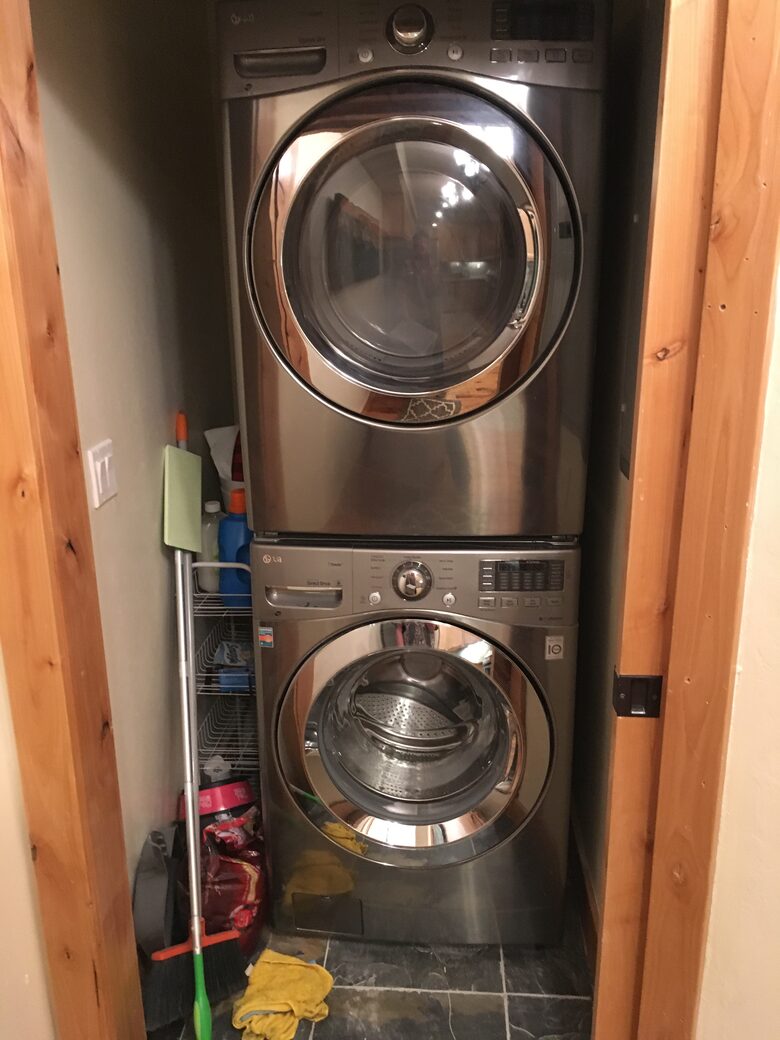 Stacked washer/dryer near kitchen.