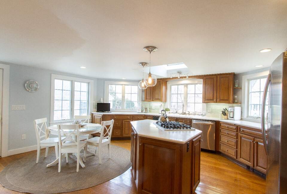 Large Kitchen with Glass Subway Tiles and Stainless Steel Appliances