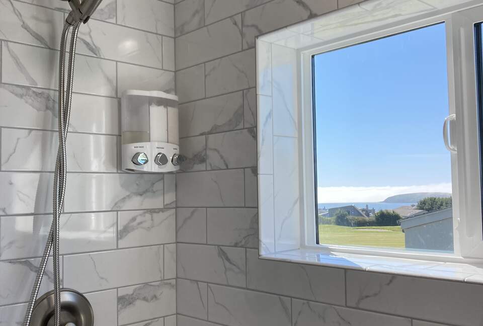 Full sized shower upstairs above garage with window view..