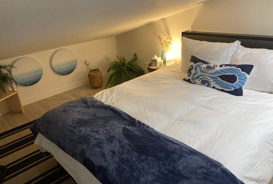 Detached guest bedroom above garage with sloped ceilings.