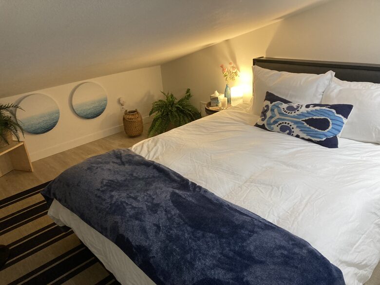 Detached guest bedroom above garage with sloped ceilings.