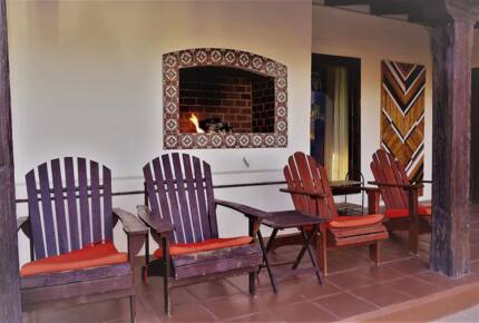 Home Exchange in Palm Springs, CA fireplace outside with lounge chairs