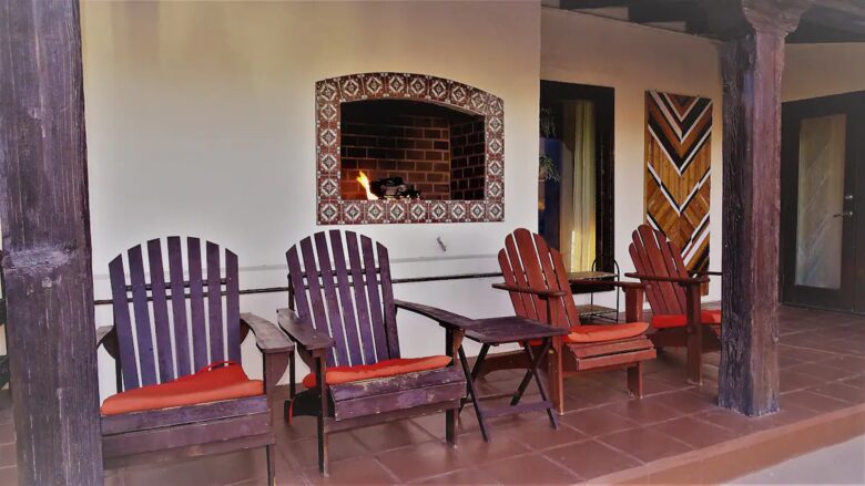 Home Exchange in Palm Springs, CA fireplace outside with lounge chairs