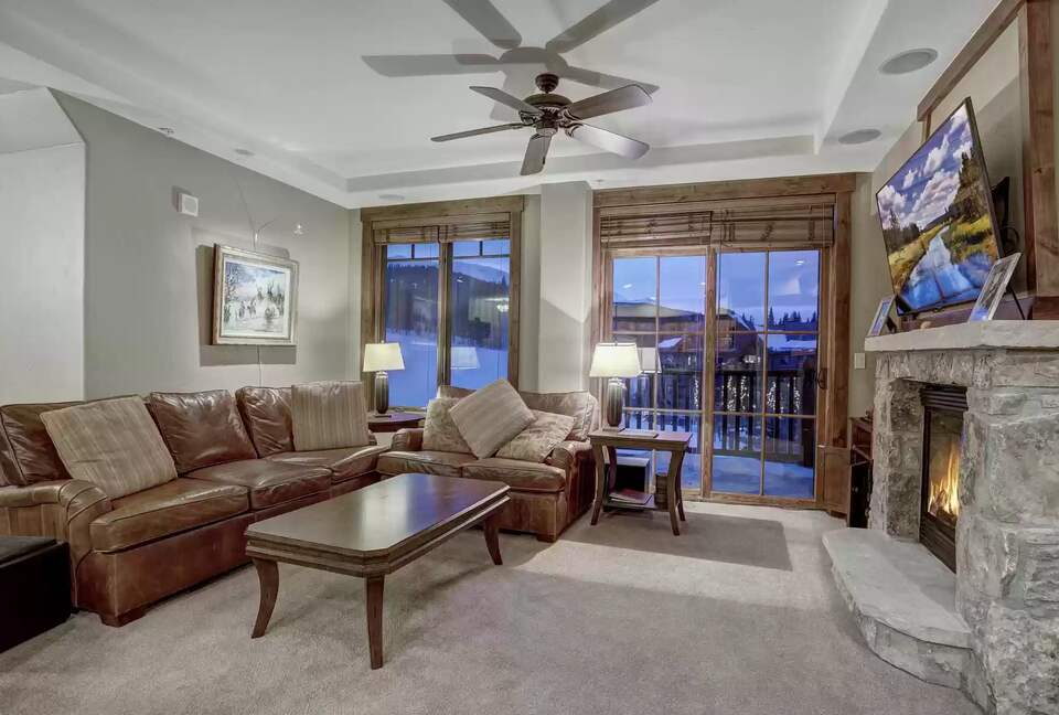 Living room with balcony and view of slope and peak 7