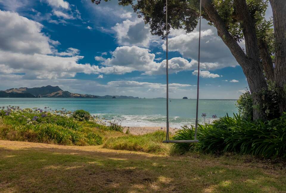 Home Exchange in Ferry Landing, Waikato, NZ swing in front of ocean
