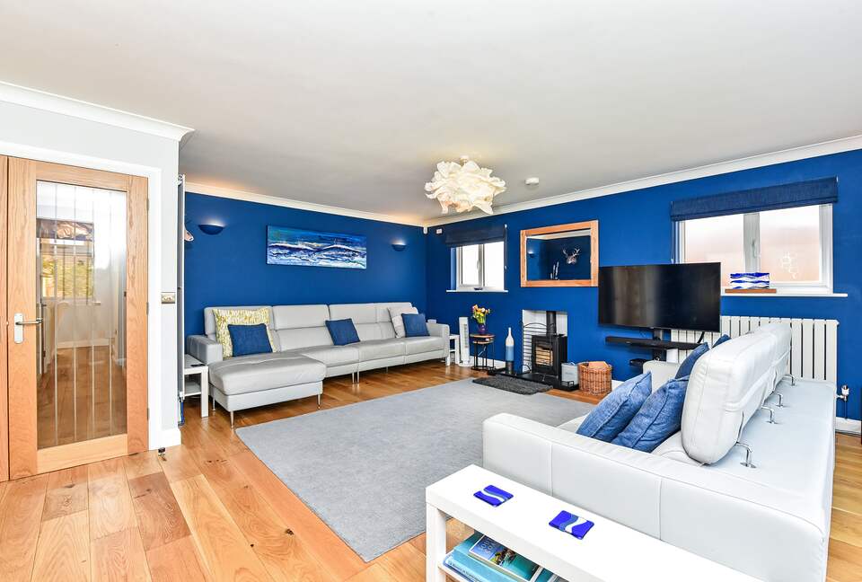 Spacious lounge area with woodturning stove and HDTV