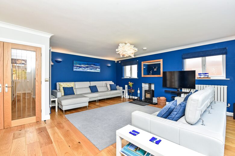 Spacious lounge area with woodturning stove and HDTV